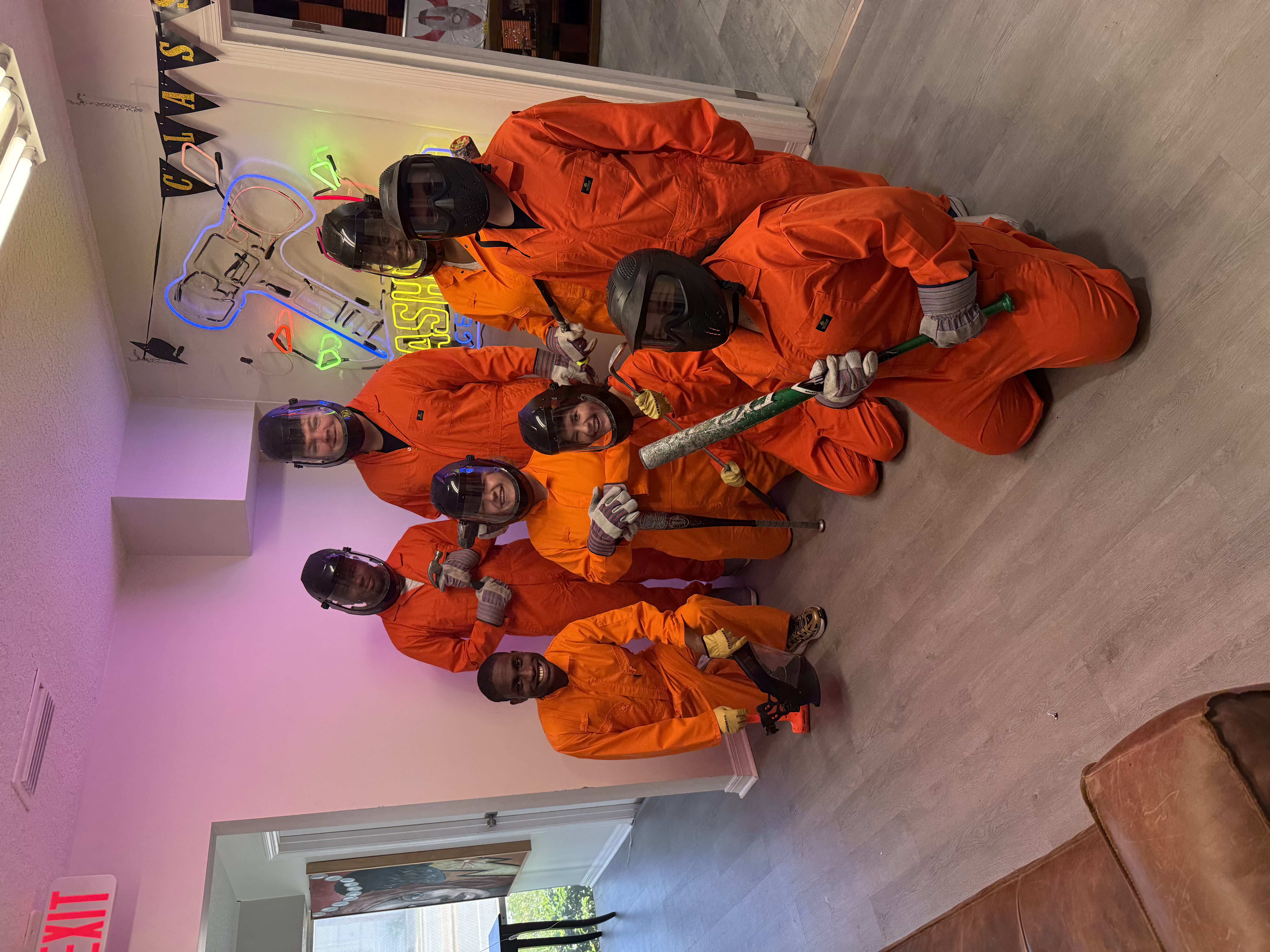 Large group of Crash Out customers in orange jumpsuits ready to smash